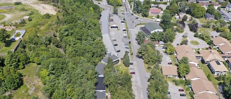 An aerial view of a residential area with houses, roads, and a parking lot.