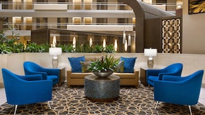 A lobby with a central seating area, a patterned floor, and a view of the building's interior.