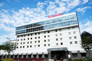 Un moderno edificio de hotel con cielo despejado y el nombre "Scandic" en la parte superior.