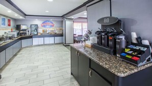 A breakfast counter with a coffee machine, a refrigerator, and a menu board. - Americas Best Value Inn Canton (Canton)