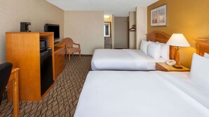 A hotel room with two beds, a desk with a television, a chair, a desk lamp, and a telephone. - Americas Best Value Inn Canton (Canton)