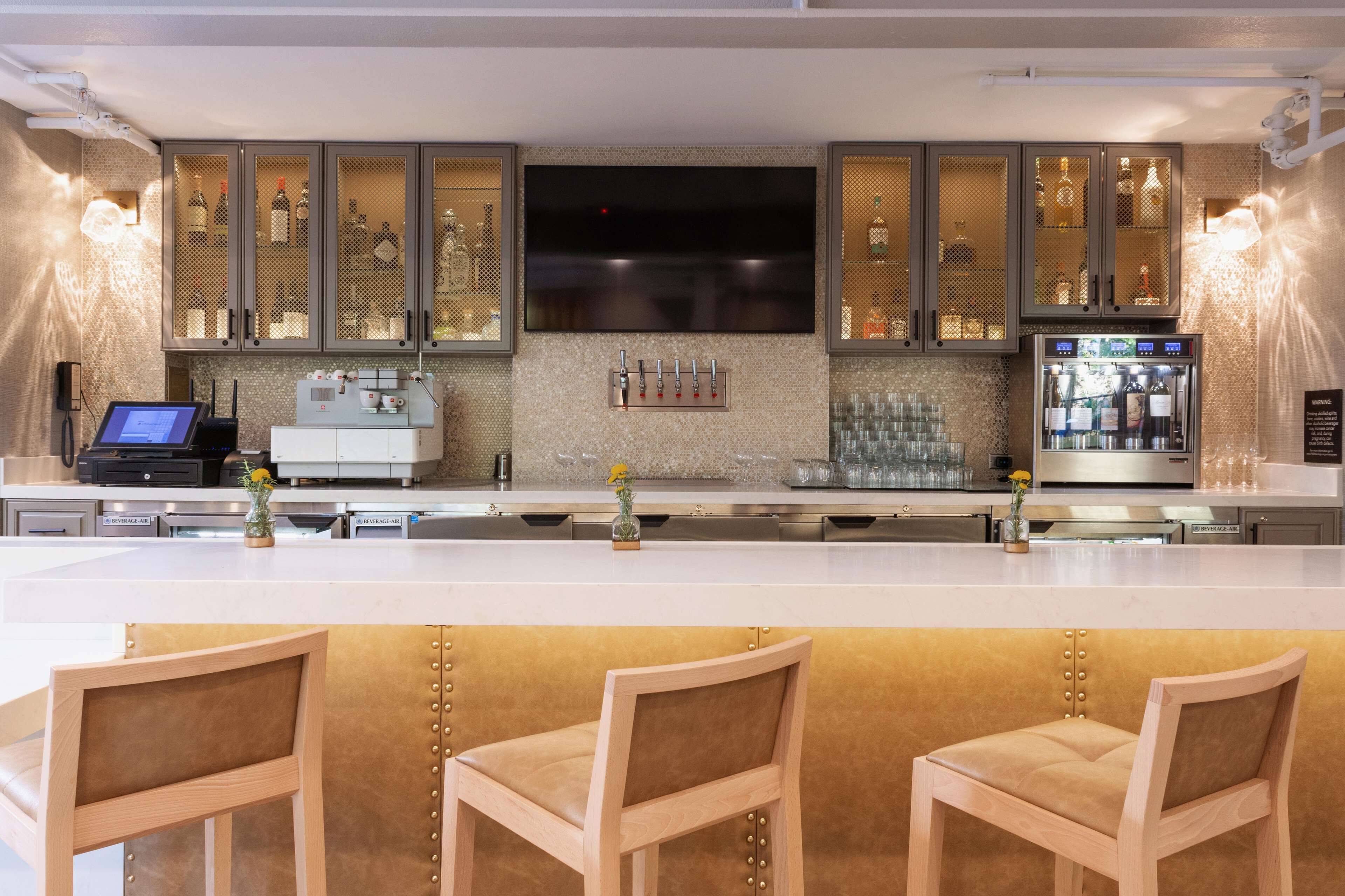 A modern kitchen with a large island, bar area, and seating.