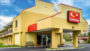 A yellow EconoLodge building with a red roof and a sign. - Econo Lodge Brockport (Brockport)