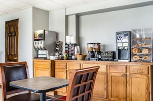 Una cocina con armarios de madera, una cafetera y un refrigerador.