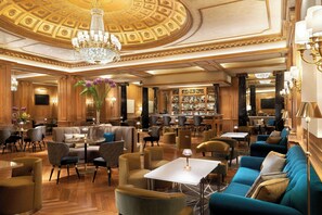 A luxurious hotel lobby with a grand chandelier, plush seating, and a bar area. - The Westin Palace, Milan (Milan)