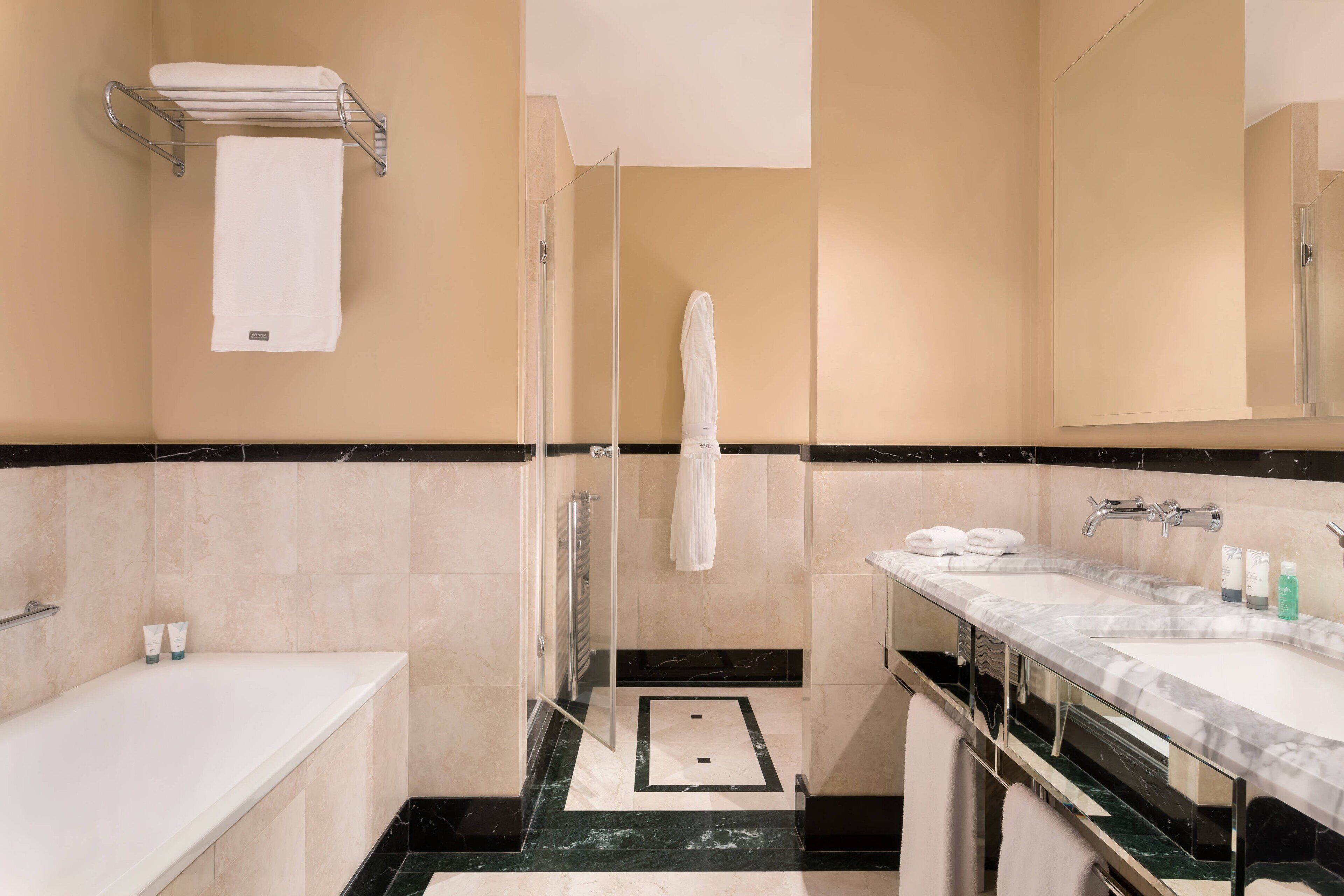 Une salle de bain moderne équipée d’une baignoire, d’une douche, d’un meuble-lavabo et d’un porte-serviettes.