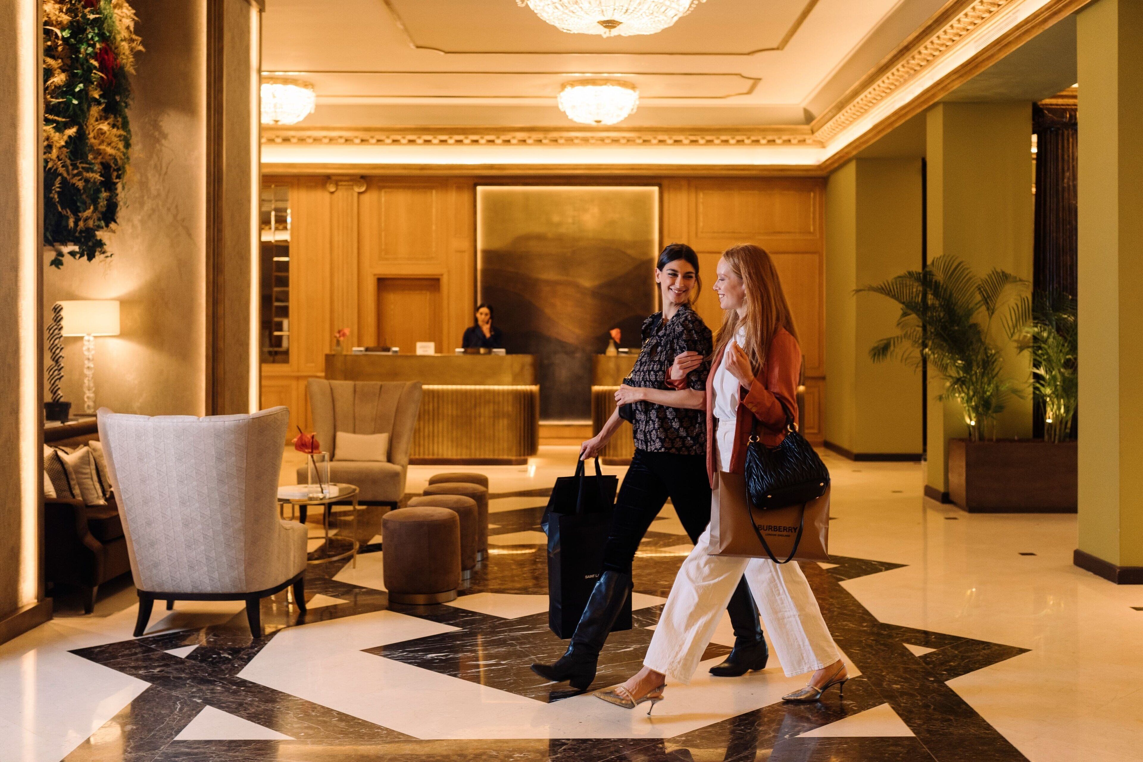 A lobby with a reception desk, seating area, and a check-in counter.