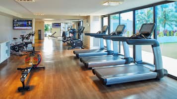 A gym with treadmills, stationary bikes, and a rowing machine.