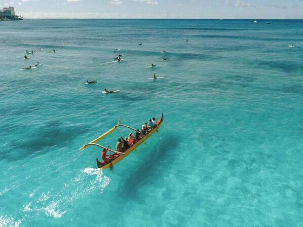 A traditional boat with passengers, sailing on clear turquoise waters.