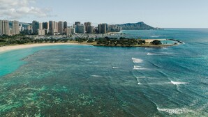 A coastal cityscape with a beach, clear blue waters, and a mountain in the background. - Holiday Inn Express Waikiki by IHG (Honolulu)