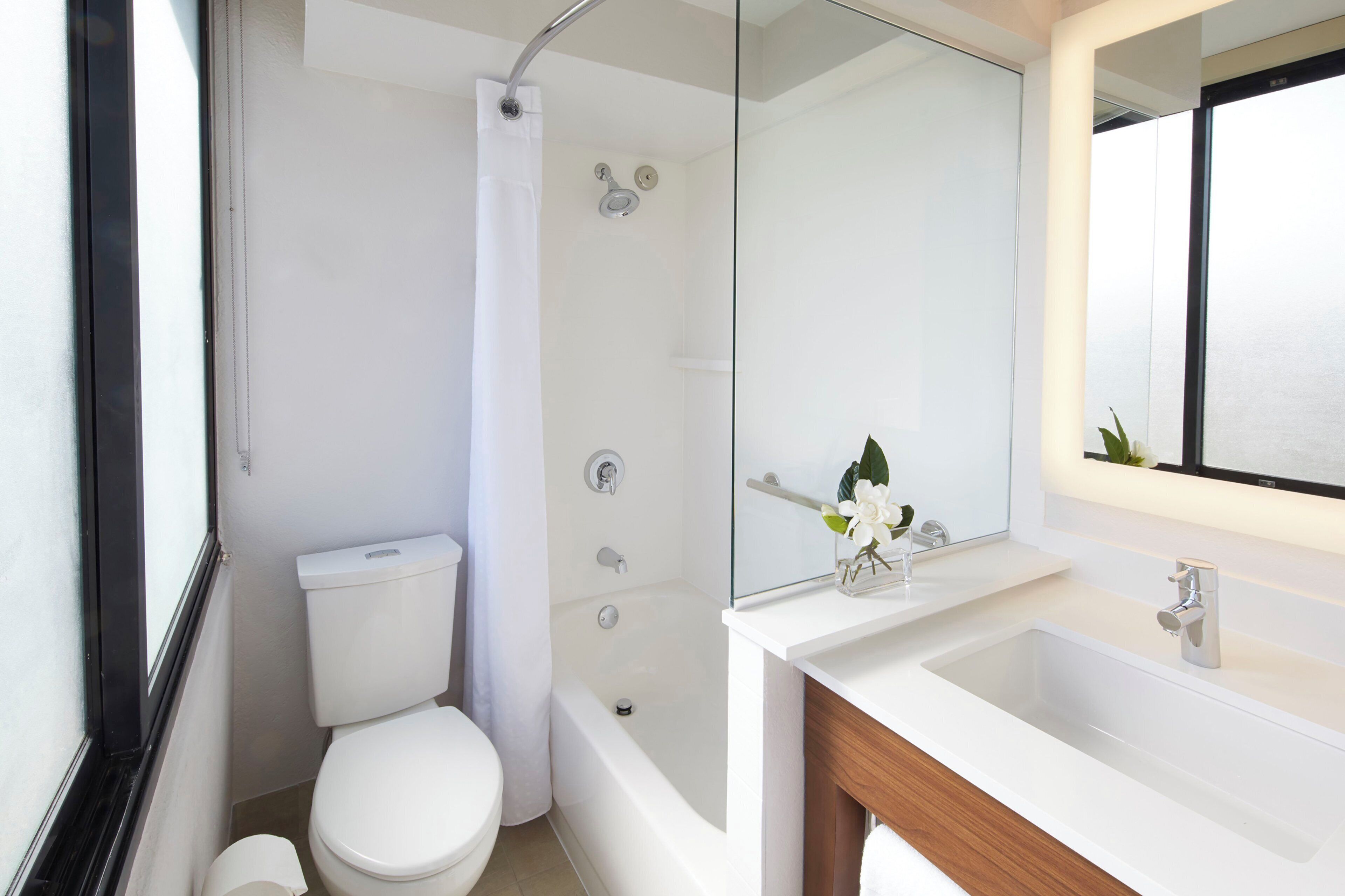 Une salle de bain moderne équipée de toilettes, d’une douche et d’un lavabo.