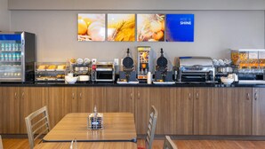 A breakfast bar with various food items and appliances, including a coffee machine and waffle maker. - Comfort Inn Kanata Ottawa West (Ottawa)