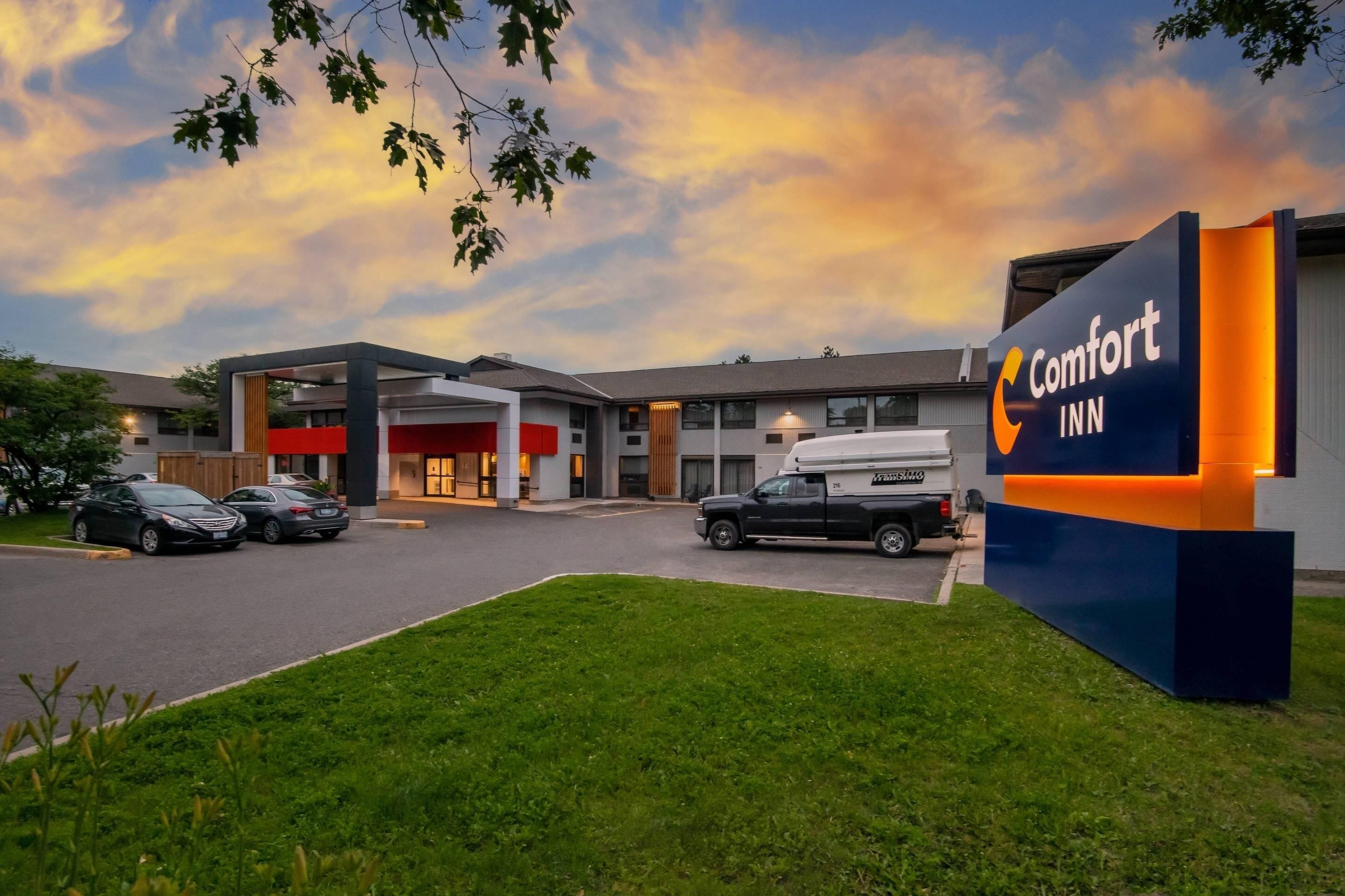 A Comfort Inn hotel with a parking lot, a truck, and a building with a sign.