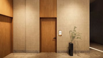 Un interior moderno con una puerta de madera, un letrero en la pared y una planta en maceta.