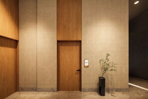 Un interior moderno con una puerta de madera, un letrero en la pared y una planta en maceta.