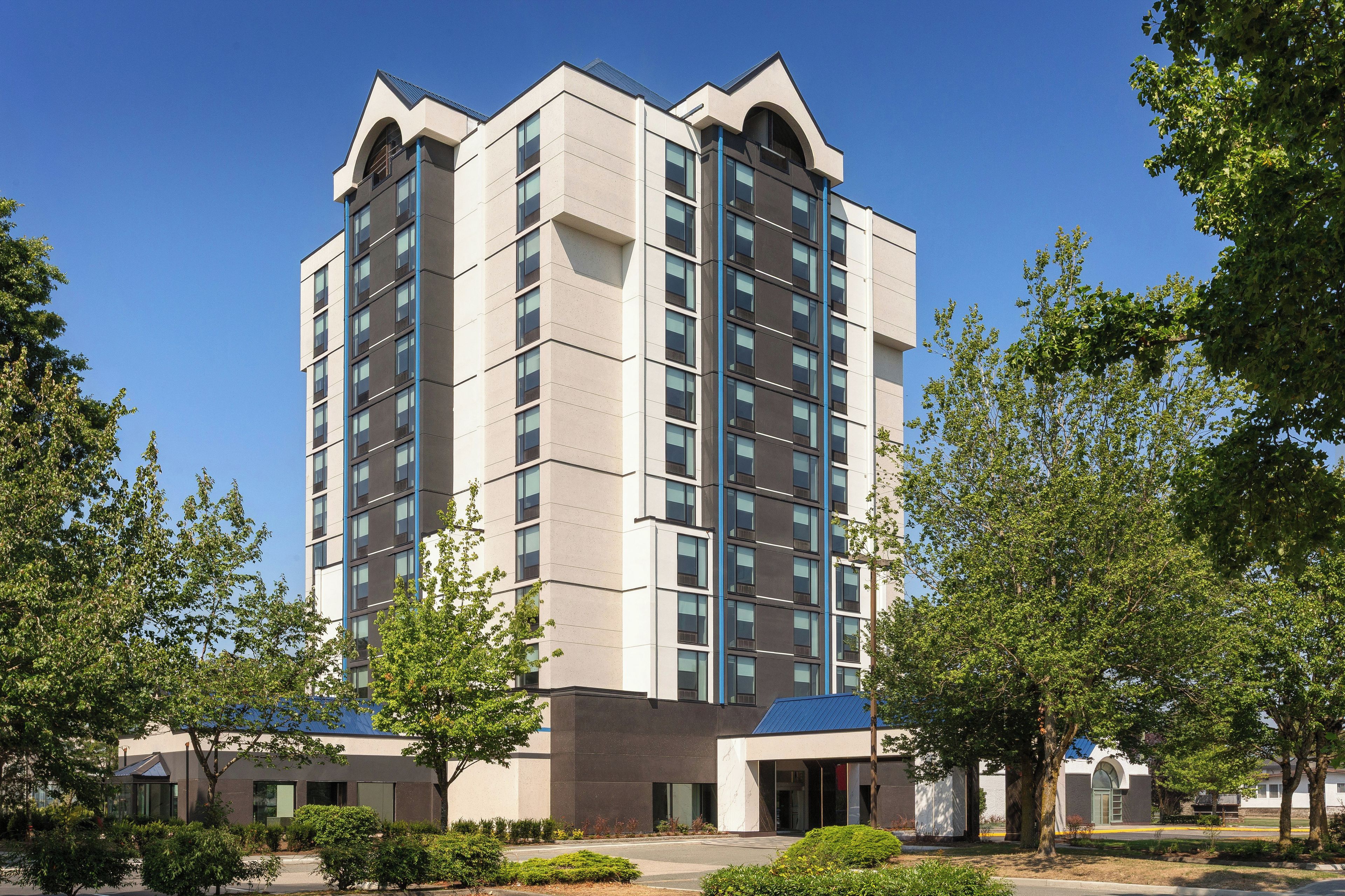 A multi-story hotel with a modern architectural design, featuring a prominent entrance and a landscaped courtyard.