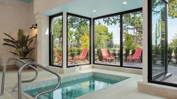 A swimming pool with a view of outdoor chairs and trees.