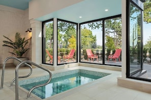 A swimming pool with a view of outdoor chairs and trees. - Red Roof Inn PLUS+ Vancouver Airport (Richmond)