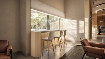 A modern bar area with a long counter and three bar stools.