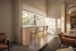 Un área de bar moderna con una barra larga y tres taburetes.