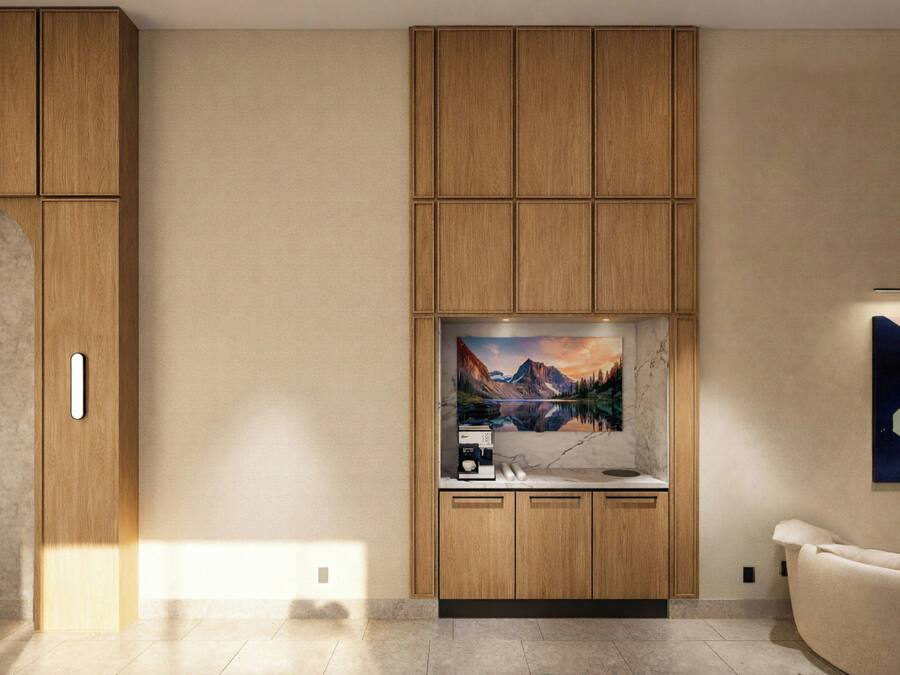 A modern kitchen with wooden cabinets, a built-in coffee station, and a painting of a mountain landscape.