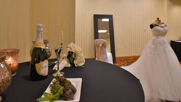 Formal events are hosted in this elegant space, featuring a round table set with champagne, dessert, and a mannequin dressed in a wedding gown.