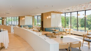 A modern restaurant with a long counter, seating area, and large windows offering a view of the outdoors. - Atlantica Hotel Halifax (Halifax)