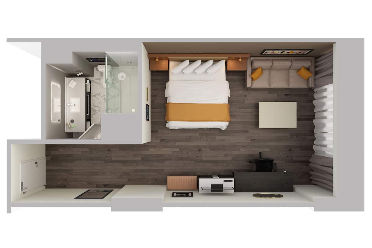 A modern hotel room with a bed, a sofa, a desk, and a bathroom.