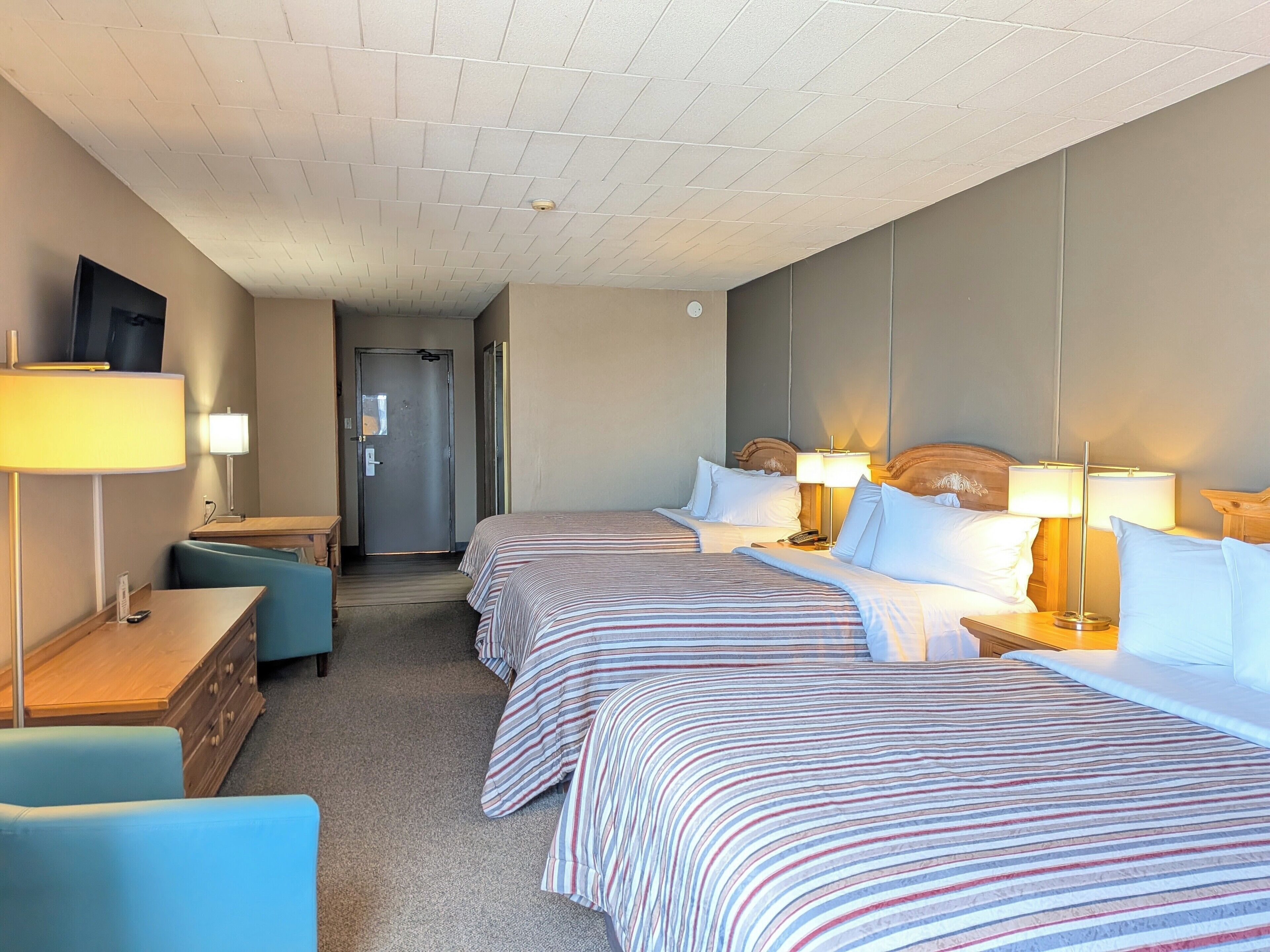 Ein Hotelzimmer mit zwei Betten, einem Schreibtisch, einem Stuhl und einem Fernseher.