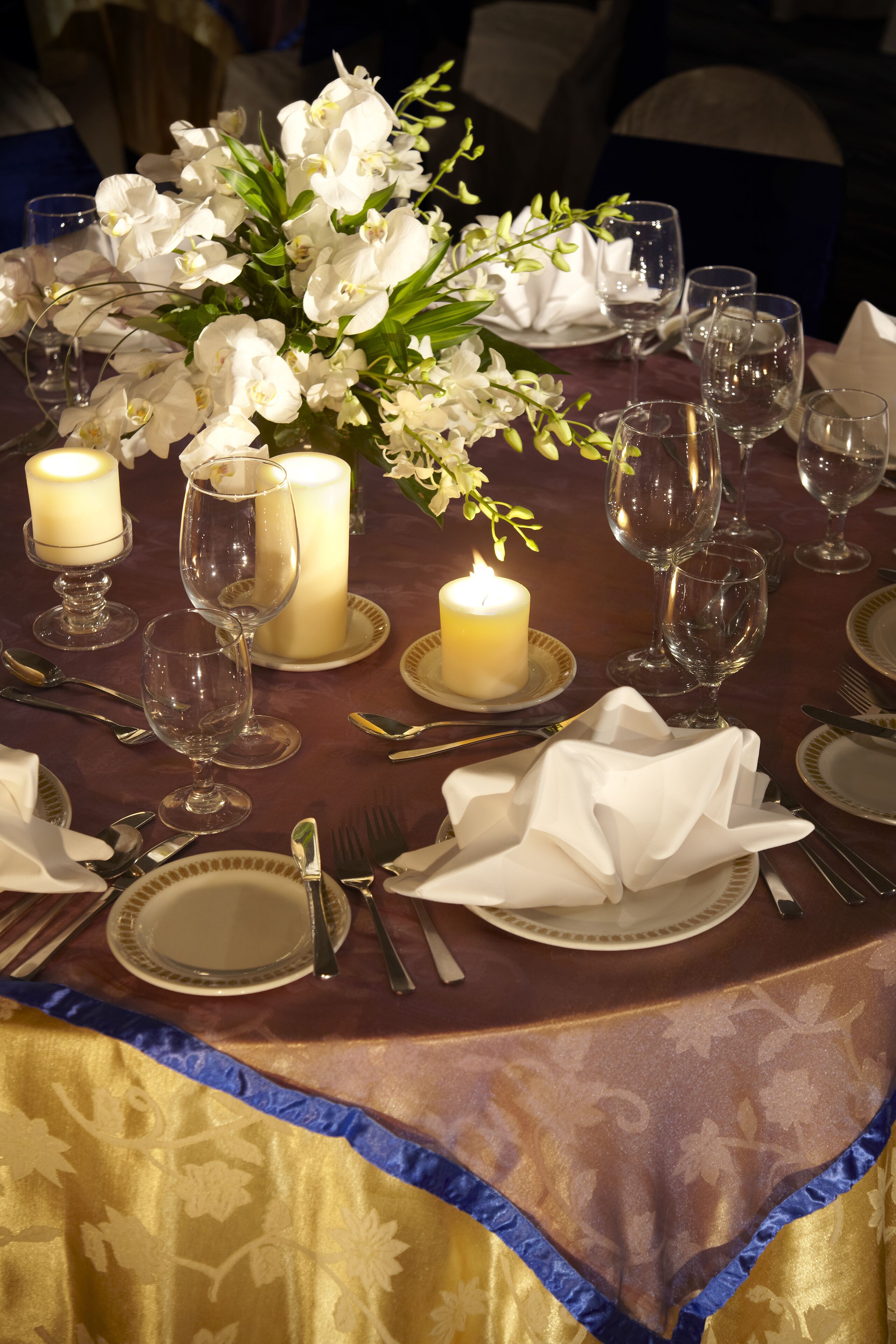 A table set for dining with candles, white flowers, and clear glassware.