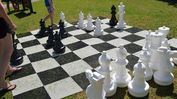 A large outdoor chessboard set up on a grassy area.