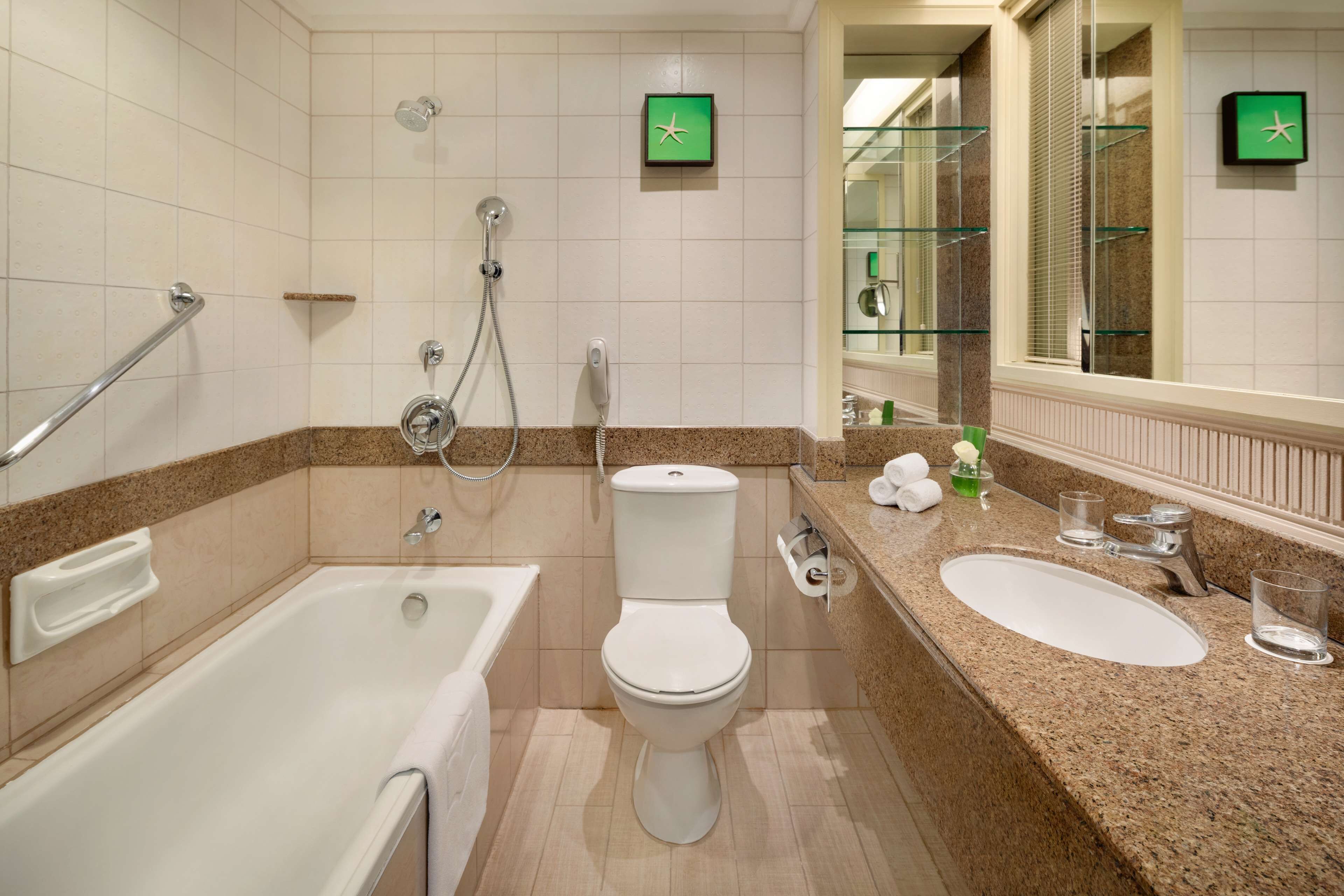 A bathroom with a bathtub, toilet, and two sinks.
