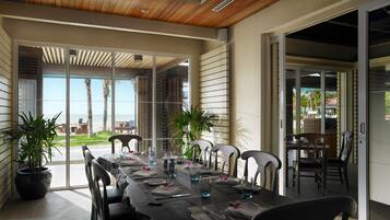 Un comedor con una mesa larga dispuesta para seis comensales, rodeada de sillas, y vistas al exterior.