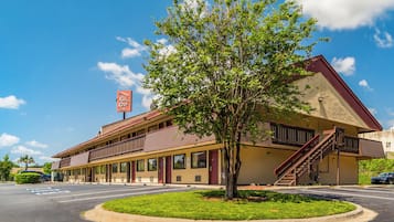 A two-story motel with a red roof and a sign that reads 'Red Roof.'
