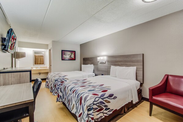 A hotel room with two beds, a desk, a chair, a TV, and a bathroom. - Red Roof Inn Columbia East - Ft Jackson (Columbia)