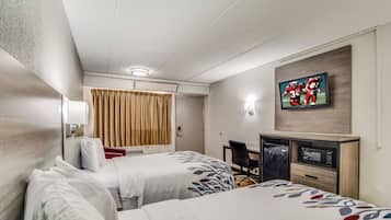 A hotel room with two beds, a desk, a television, and a minibar.
