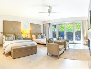 Relax in a spacious room with a large bed, sofa, and armchair, and enjoy a view of the outdoors through the large window.