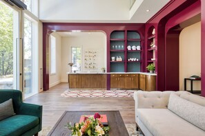 Relax in the living area with a view of the outdoors, featuring a comfortable sofa and armchair.