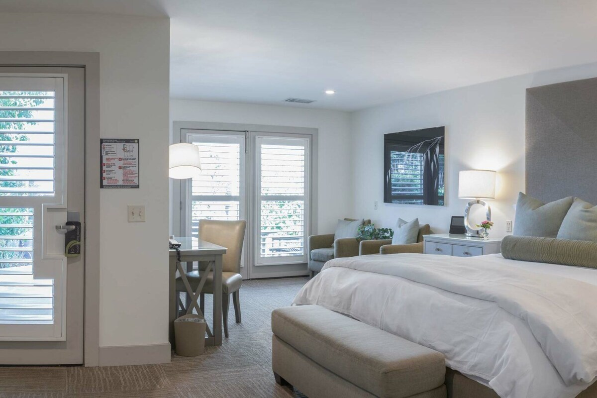 Une chambre à coucher avec un grand lit, des tables de chevet, un bureau et une chaise.