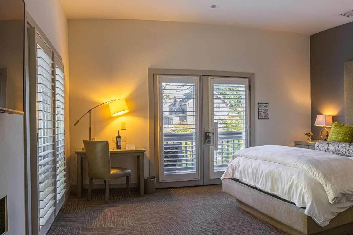 A bedroom with a bed, two bedside tables, a desk, and a chair.