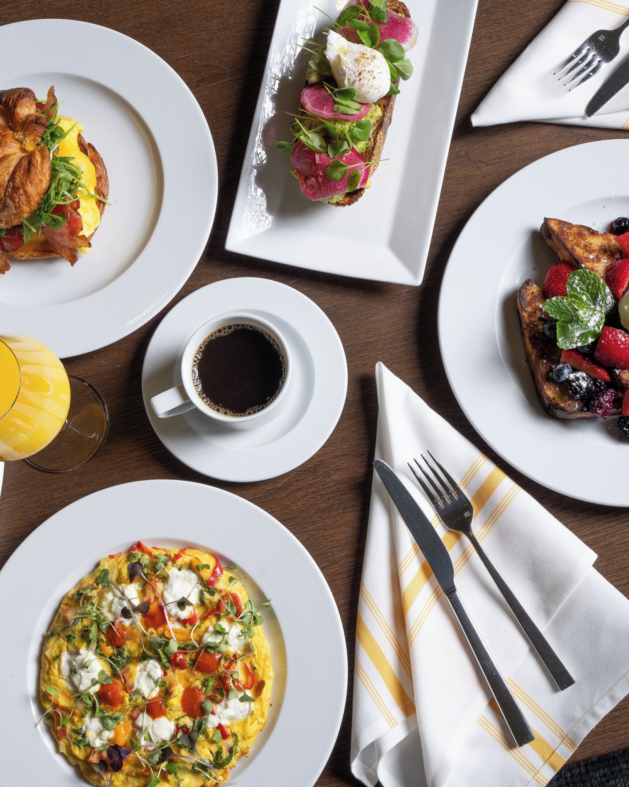 A breakfast setting with various dishes, including toast, eggs, and a cup of coffee.