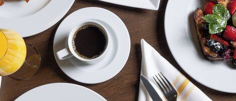 A breakfast setting with various dishes, including toast, eggs, and a cup of coffee.