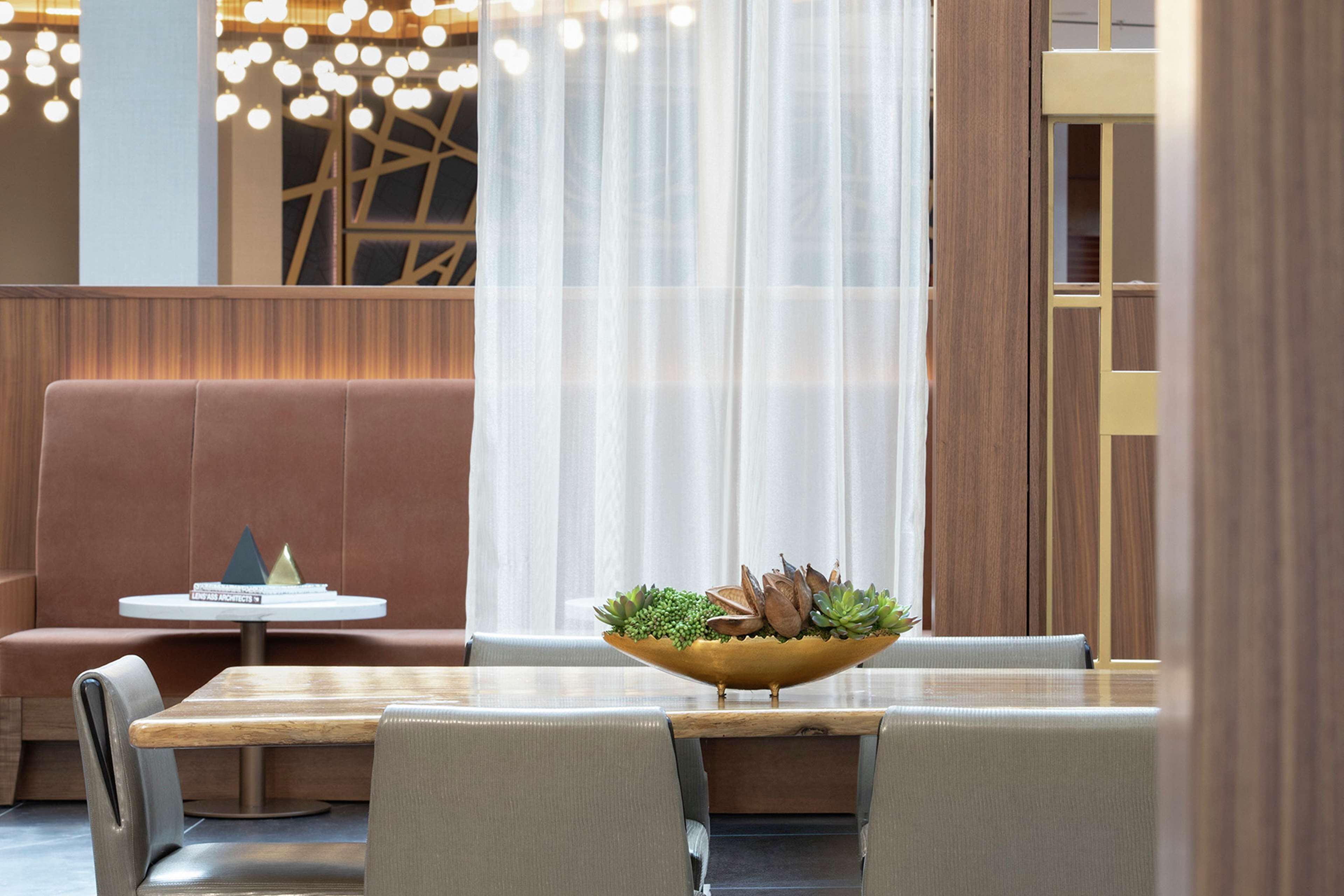 A modern dining area with a round table, cushioned seating, and a decorative bowl centerpiece.