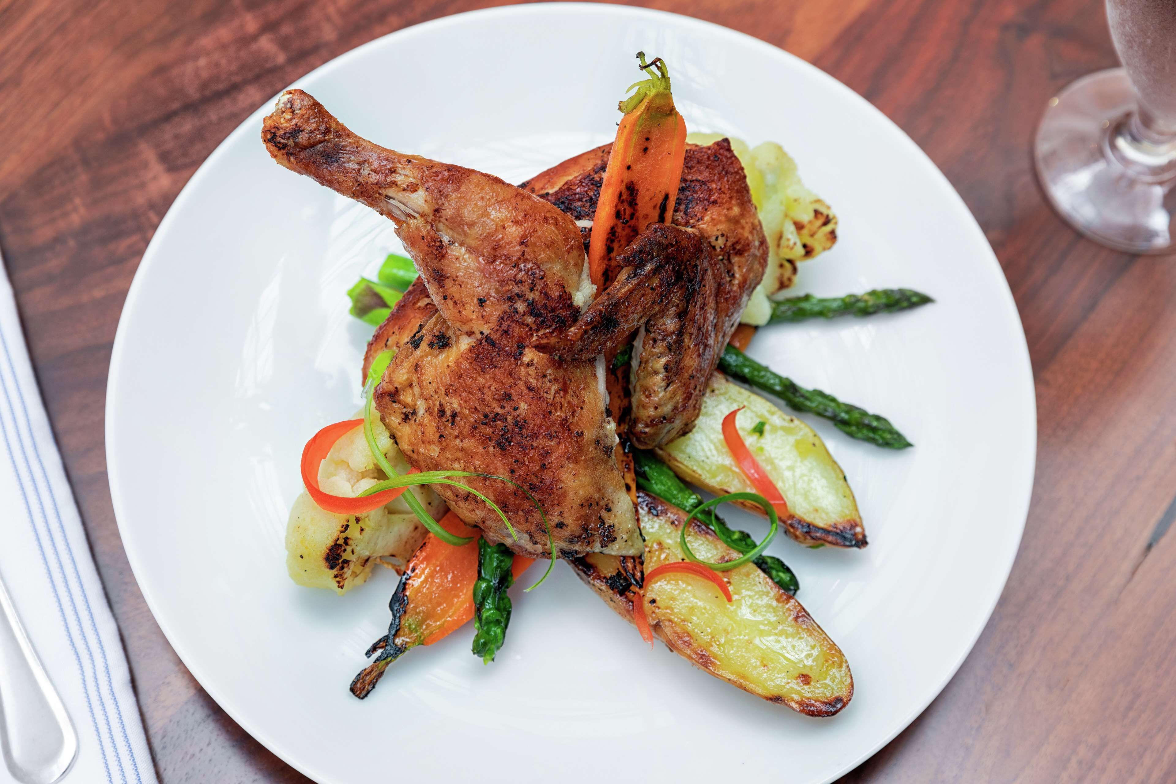 A plate of roasted chicken with vegetables.