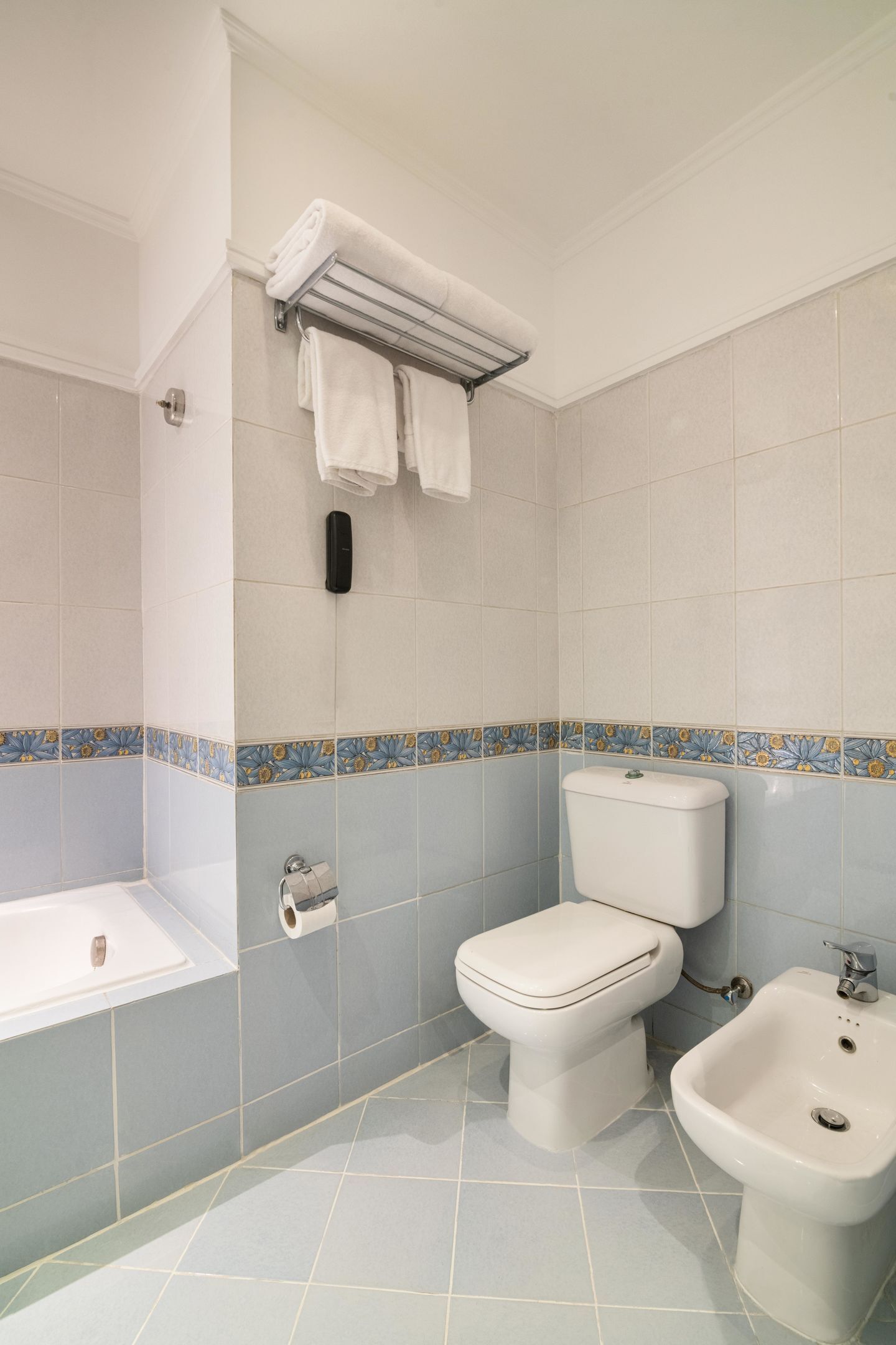 Ein Badezimmer mit Badewanne, Toilette, Bidet und Handtuchhalter.
