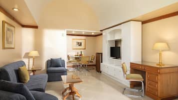 Una sala de estar con sofá, mesa de comedor, televisor y escritorio.