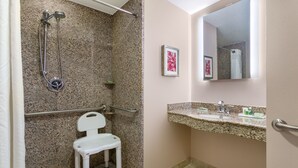 Ein Badezimmer mit Dusche, Toilette, Waschbecken und Spiegel.
