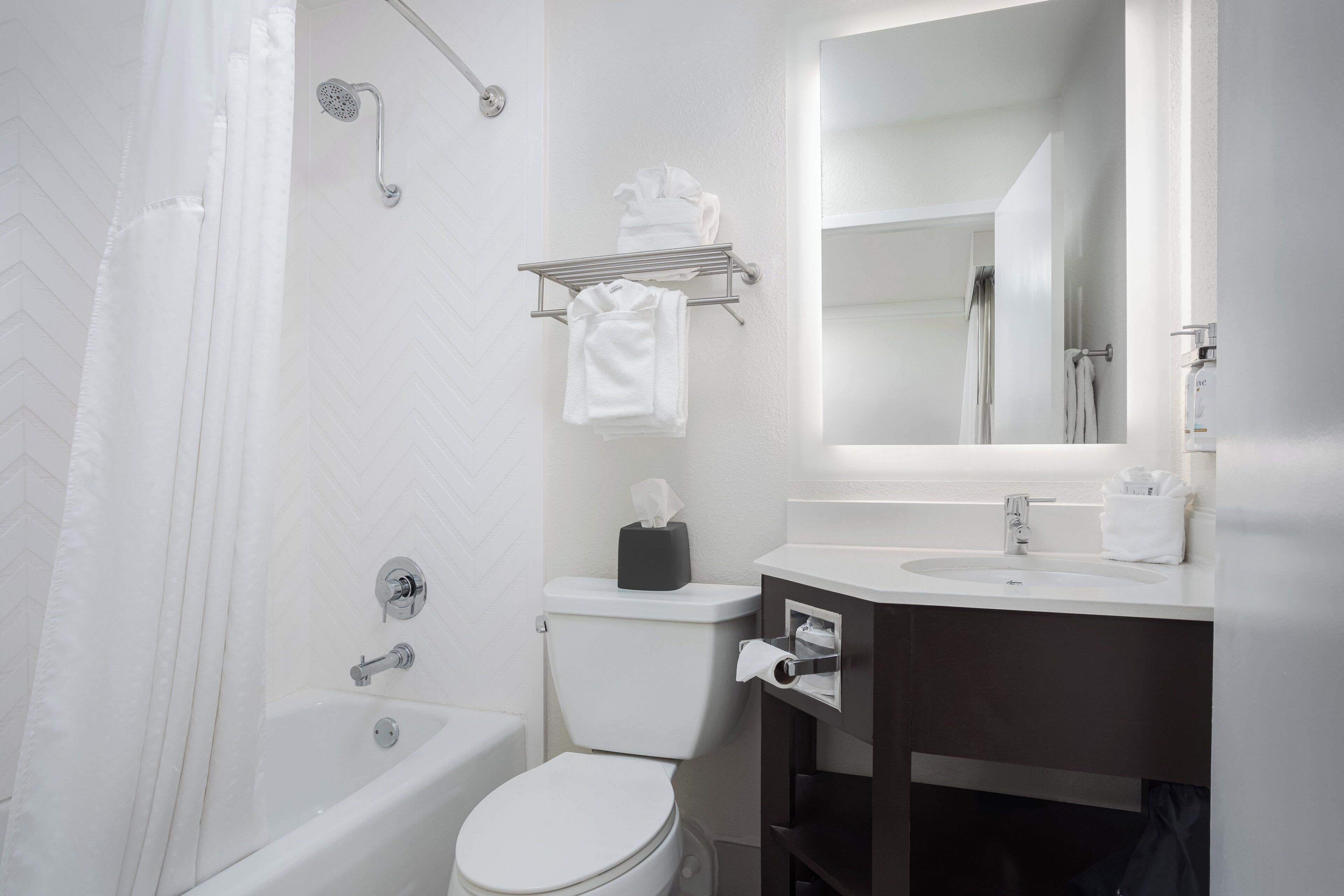 A modern bathroom with a bathtub, toilet, and sink.