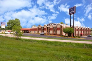 A hotel with a central courtyard, multiple floors, and a prominent American Inn sign. - AmericInn by Wyndham Janesville (Janesville)