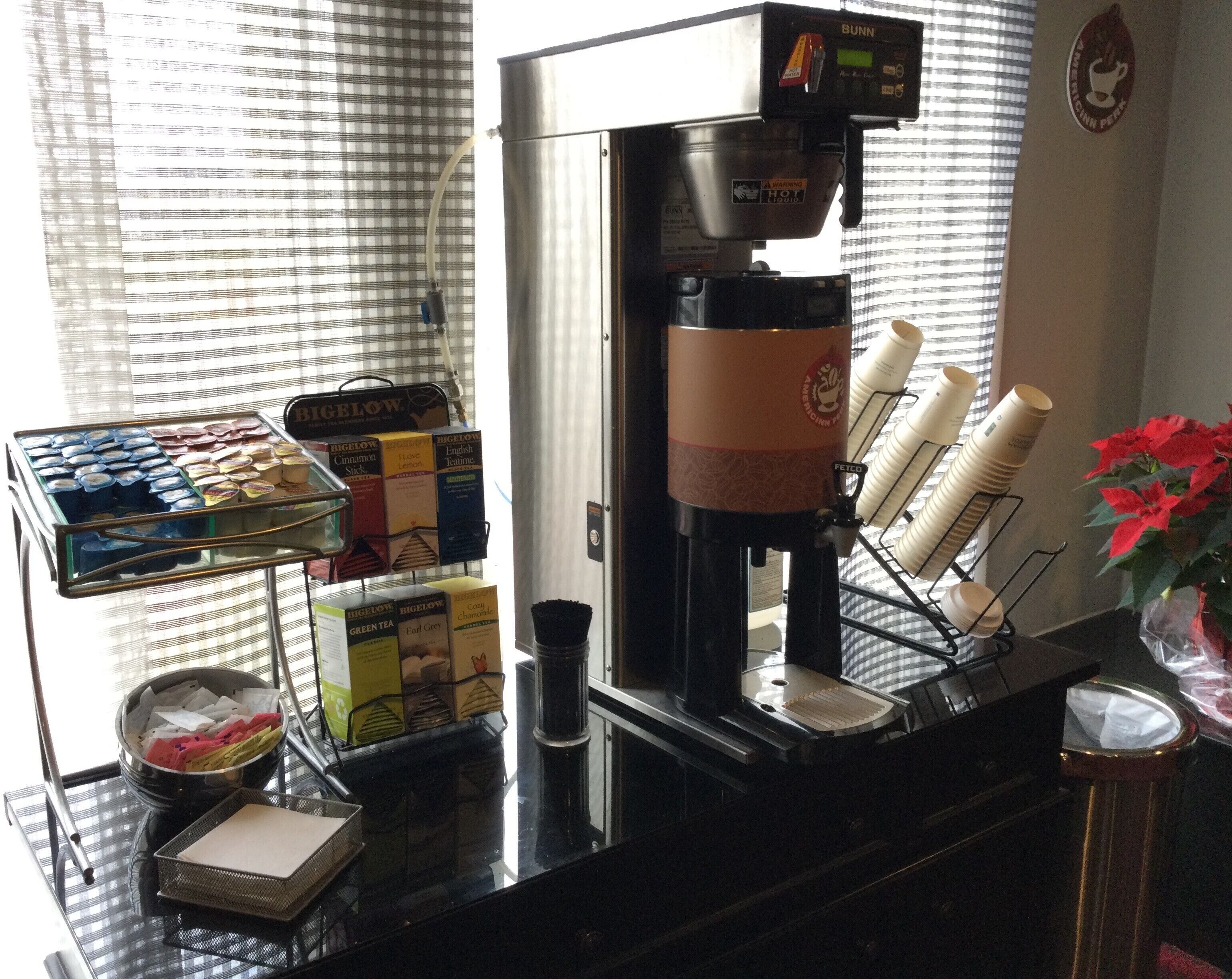 A coffee machine with a display screen, a coffee cup holder, and a tray of coffee pods.